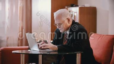 <strong>年迈</strong>的祖父-戴着眼镜和夹克的老祖父正在电脑上打字